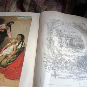 May include: An open book with a black and white illustration on the right page and a color illustration on the left page. The right page has the title 'The Sunday at Home' and the text 'Family Magazine for Sabbath Peace 1887' and 'Religious Tract Society Paternoster Row 164 Piccadilly.' The left page has a color illustration of a woman in a red dress holding a young child in a white dress. A man in a pink and black robe is standing behind the woman and touching the child's head.