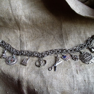 sterling silver charm bracelet  9 charms, cat, twin towers, USA flag, mother, scissors, and more, safety clasp, interlocking links,