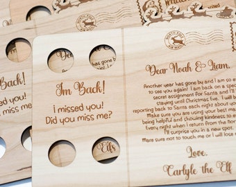 May include: A set of wooden Christmas postcards with a Santa Claus and reindeer design. The postcards have a message that says "Im Back! I missed you! Did you miss me?" and "Dear Noah & Liam. Another year has gone by and I am so excited to see you again! I am back on a special secret assignment for Santa and I'll be staying until Christmas Eve. I will be reporting back to Santa each night about you. Make sure you are using your best manners being helpful and showing kindness to everyone. Every night when I return from the North Pole I'll surprise you in a new spot. Make sure not to touch me or I will lose my magic. Love. Carlyle the Elf."