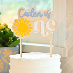 Spersonalizowana ozdoba na tort urodzinowy z motywem słońca na pierwsze urodziny dziewczynki lub chłopca w kolorze żółtego słońca. Pierwsze urodziny.