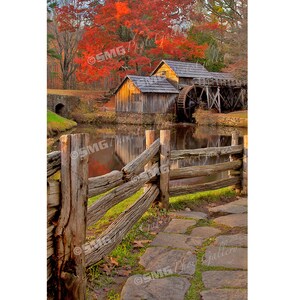 May include: A scenic landscape featuring a wooden water mill with a large water wheel, set beside a calm pond. The mill is surrounded by trees with vibrant red and orange foliage, a stone path, and a rustic wooden fence.