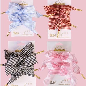 May include: Four pairs of gingham shoelaces in blue, red, black, and pink. Each pair is tied into a bow and displayed on a white card with gold aglets. The cards read "STEP IT UP shoelaces" and "the darling effect."