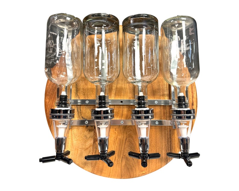 May include: A wooden wall-mounted liquor dispenser with four clear glass bottles and chrome spouts. The dispenser has a round wooden base and metal brackets.