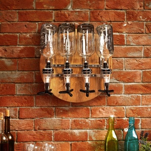 May include: A wooden wall-mounted liquor dispenser with four clear glass bottles and metal spouts. The dispenser has a circular wooden base and metal accents.