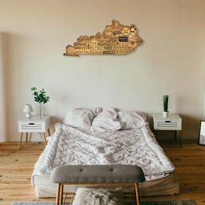 Pu&ograve; includere: Un'opera d'arte murale in legno a forma dello stato del Kentucky con i nomi delle citt&agrave; e dei paesi di tutto lo stato. L'opera d'arte &egrave; appesa a una parete di una camera da letto con un letto, comodini e una libreria.