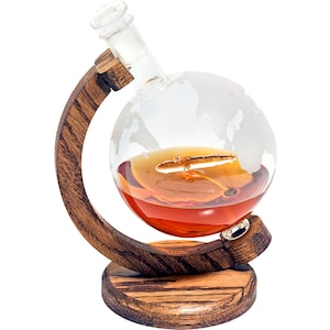 May include: A glass globe decanter with a wooden stand shaped like a globe. The decanter is filled with amber liquid and has a world map etched on the surface.