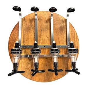 May include: A wooden wall-mounted liquor dispenser with four chrome liquor bottles and black spouts. The dispenser has a round wooden base and metal brackets.