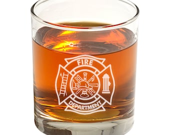Può includere: Un bicchiere di vetro trasparente con un logo del corpo dei vigili del fuoco inciso sul lato. Il logo presenta una scala incrociata, un'ascia e una manichetta, con un casco da pompiere al centro. Il testo "FIRE DEPARTMENT" è scritto sotto il logo.