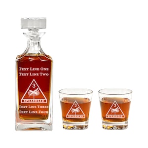 May include: A set of three clear glass decanters with a red inscription. The decanter is engraved with the text "TEXT LINE ONE TEXT LINE TWO 3 SPEARHEAD TEXT LINE THREE TEXT LINE FOUR". The two smaller glasses are engraved with the text "3 SPEARHEAD".