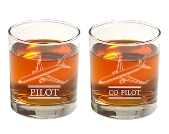 May include: Two clear glass whiskey tumblers with etched airplane designs. One tumbler says "PILOT" and the other says "CO-PILOT".