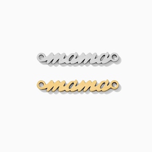 Puede incluir: Dos abalorios de metal con la palabra "mama" escrita en letra cursiva. El abalorio de arriba es plateado y el de abajo es dorado.