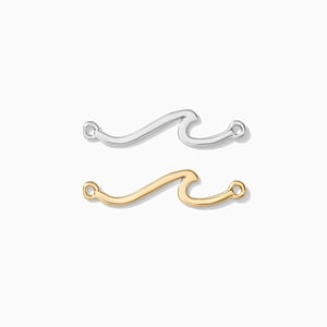 May include: Two wave-shaped charms, one silver and one gold, with a loop at each end for attaching to jewelry.