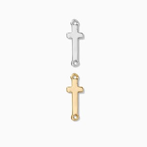 May include: Two cross charms, one silver and one gold, with a loop at the top and bottom for attaching to a necklace or bracelet.