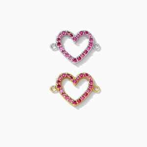 May include: Two heart-shaped charms with a pink rhinestone border. The charm on top is silver and the charm on the bottom is gold.