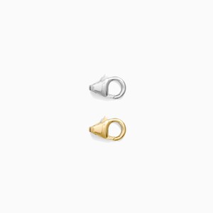 May include: Two metal lobster claw clasps. One is silver-colored, and the other is gold-colored. The clasps are designed with a rounded loop and a lever-operated spring gate for secure closure. These clasps are used for jewelry making and other crafting projects.