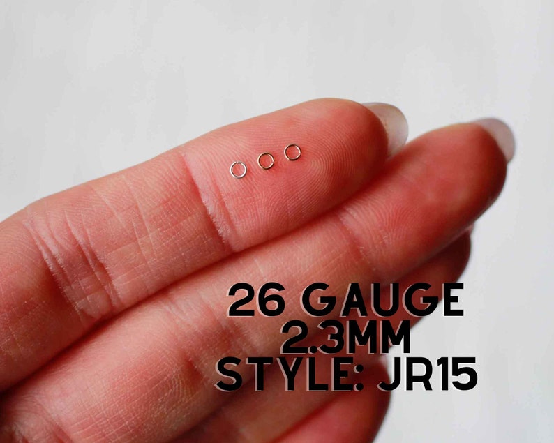 May include: Three small, silver, 2.3mm gauge, seamless rings on a finger. 26 Gauge 2.3mm Style: JR15
