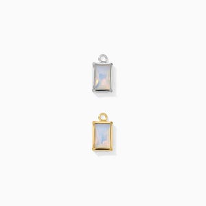 May include: Two rectangular pendants with iridescent centers. One pendant has a silver-colored frame, and the other has a gold-colored frame. Both pendants have a small loop at the top for attaching to a chain or other jewelry.