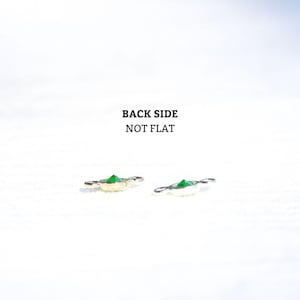May include: Two close-up images of a green gemstone charm with a gold and silver setting. The text "BACK SIDE NOT FLAT" is visible in the image.