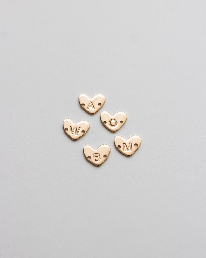May include: Five gold heart-shaped charms with the letters A, W, O, B, and M.