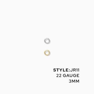 May include: Two small, circular earrings, one silver and one gold, are displayed against a white background. The text "STYLE: JR11, 22 GAUGE, 3MM" is printed below the earrings. These earrings are 3 millimeters in diameter.