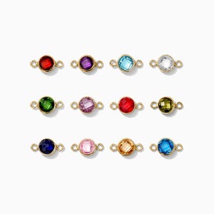May include: Twelve gold connector charms with different colored gemstones. The gemstones are red, purple, blue, clear, green, pink, orange, and light blue.