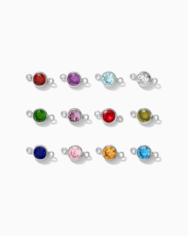 May include: Twelve silver connector charms with different colored gemstones. The charms have two loops on either side for attaching to jewelry.