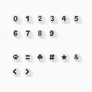 May include: White square blocks with black numbers 0-9 and symbols including a paw print, equals sign, clover, hashtag, star, ampersand, and angle brackets. The blocks are arranged in rows on a white background.