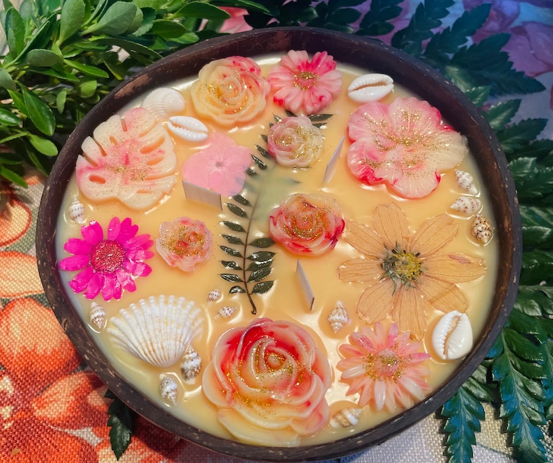 Op de afbeelding: Een ronde houten kom gevuld met verschillende kleurrijke wax melts, waaronder bloemen, schelpen en bladeren. De wax melts zijn in een decoratief patroon gerangschikt en klaar om te worden gebruikt in een wax warmer.