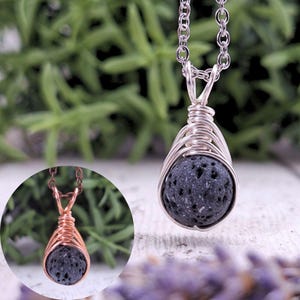 Peut inclure: Un collier pendentif argenté avec une pierre poreuse gris foncé enveloppée de fil. Le pendentif est suspendu à une fine chaîne. Un petit pendentif cuivré avec une pierre similaire est montré dans un encart circulaire.