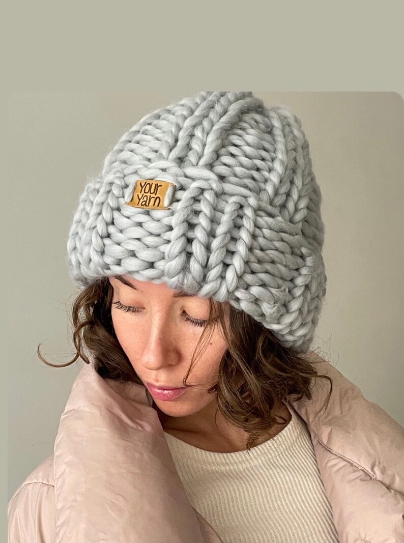 May include: A grey knitted beanie with a brown leather tag that says "Your Yarn".
