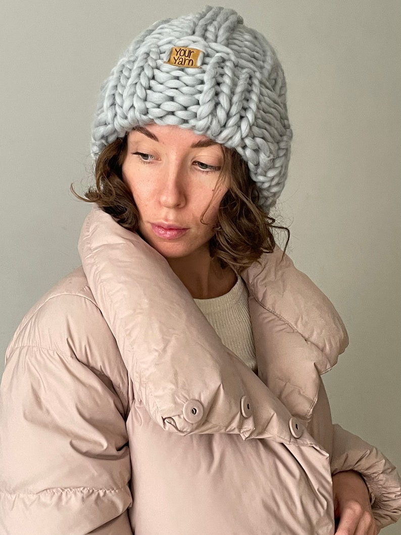May include: A grey knitted beanie with a brown leather tag that says "Your Yarn".
