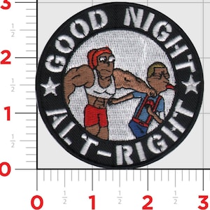 May include: A black and white embroidered patch with a white circle containing two cartoon figures. The text "GOOD NIGHT ALT-RIGHT" is written in a white circle around the figures.
