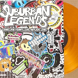 May include: A vinyl record with a bright orange colored disc and a colorful album cover featuring the text "Suburban Legends" and "Songs You Might Like, But We Love".