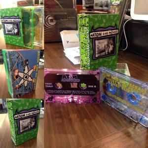 May include: A collection of cassette tapes with green, purple, and blue packaging. The tapes feature the text "Atom & His Package" and "Society of People Named Eltro".