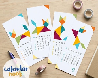 May include: Four vertical paper calendars featuring geometric tangram-style cat illustrations in orange, yellow, teal, magenta, and green. Each calendar displays a monthly grid with days of the week and dates. One calendar is labeled OCT 2027.