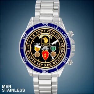 May include: A silver watch with a blue bezel and a black face. The face features the text "U.S. ARMY 25TH INF" and "1ST BN 27TH INF REG WOLFHOUNS" along with a wolfhound emblem and military medals.