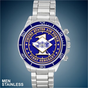 May include: A silver watch with a blue face and a gold trim. The face of the watch has a blue background with a gold star and the words "United States Air Force" and "First Sergeant".