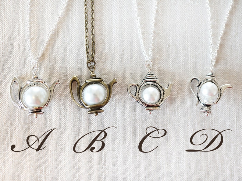 May include: Four silver and bronze necklaces with teapot pendants and white pearl accents. The pendants are labeled A, B, C, and D.