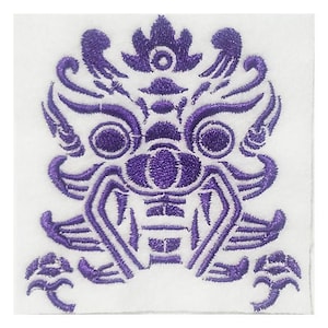 Puede incluir: Parche bordado morado con un diseño detallado de una criatura mítica con una expresión feroz. La criatura tiene ojos grandes, una boca ancha y patrones intrincados en todo su cuerpo.