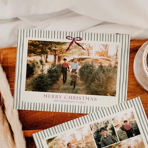 Könnte beinhalten: Zwei Weihnachtskarten mit Familienfotos und dem Text "MERRY CHRISTMAS" und "The Thompson Family." Die Karten haben einen gestreiften Rand und eine bordeauxfarbene Schleife. Eine brennende Kerze in einem Glasgefäß befindet sich in der Nähe.