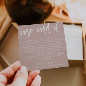 Puede incluir: Una tarjeta de cuidado de color marrón claro con texto blanco y un símbolo de corazón. La tarjeta proporciona instrucciones sobre cómo cuidar las joyas, incluyendo guardarlas en una caja o bolsa forrada de tela suave, mantener las piezas separadas, evitar nadar con joyas y limpiarlas con agua tibia y jabón sin detergente. La tarjeta incluye iconos de redes sociales y el texto "@yourbusiness - www.yourbusiness.com".