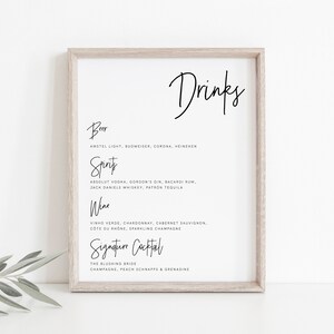 Könnte beinhalten: Ein gerahmtes, druckbares Schild mit dem Wort "Drinks" oben. Das Schild listet verschiedene Arten von alkoholischen Getränken auf, darunter Bier, Spirituosen, Wein und einen Signature-Cocktail. Der Signature-Cocktail heißt "The Blushing Bride" und wird aus Champagner, Pfirsichschnaps und Grenadine hergestellt.