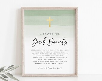 Puede incluir: Una impresión enmarcada con un fondo de acuarela en tonos verdes. La impresión presenta una cruz dorada y el texto "Una oración para Jacob Daniels." El texto continúa con una oración para el niño, terminando con "Bautizado el 14 de junio de 2021."