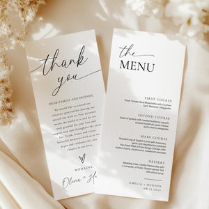Puede incluir: Dos tarjetas de papelería de boda. Una dice "thank you" en escritura cursiva, la otra "the MENU". La tarjeta del menú enumera platos como "Roasted Leg of English Lamb". Ambas tarjetas están sobre una superficie crema.
