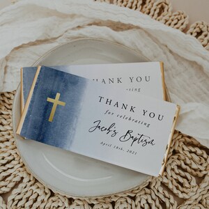 May include: Two white thank you cards with blue watercolor backgrounds and gold crosses. The text on the cards reads "Thank you for celebrating Jacob's Baptism April 18th, 2021".