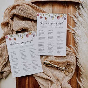 May include: Two floral-themed game cards with the title "What's in your purse?"  The cards list various items with point values assigned to each.  The cards are on a wooden surface with a beige fabric and gold wax seals.