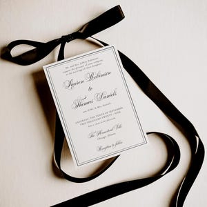 Puede incluir: Una invitaci&oacute;n de boda con una cinta negra. La invitaci&oacute;n es blanca con texto negro, incluyendo los nombres Lauren Robinson y Thomas Daniels, y la fecha de la boda. La cinta negra est&aacute; atada en un lazo.