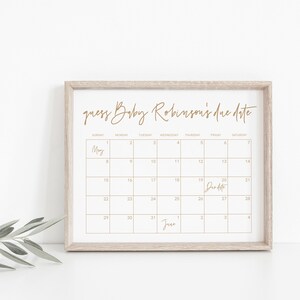 Op de afbeelding: Een afdrukbare kalender met een gouden frame, met een kalender voor de maand mei met de tekst "guess Baby Robinson's due date" bovenaan. De uitgerekende datum is op de kalender gemarkeerd als de 20e mei.