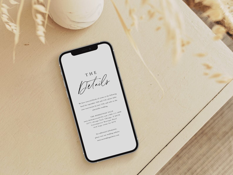 May include: A white smartphone with a black border displays a wedding invitation with the text "THE Details" and information about the wedding venue, date, and contact information.
