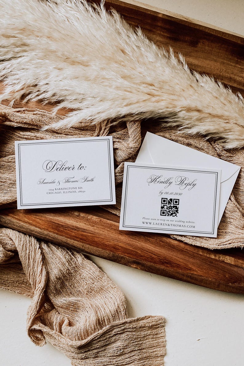 Puede incluir: Dos tarjetas de invitaci&oacute;n de boda blancas con texto negro y borde negro, una con la leyenda "Deliver to:" y la otra "Kindly Reply". Un c&oacute;digo QR est&aacute; en la segunda tarjeta. Las tarjetas est&aacute;n sobre una bandeja de madera con tela beige y plantas secas.